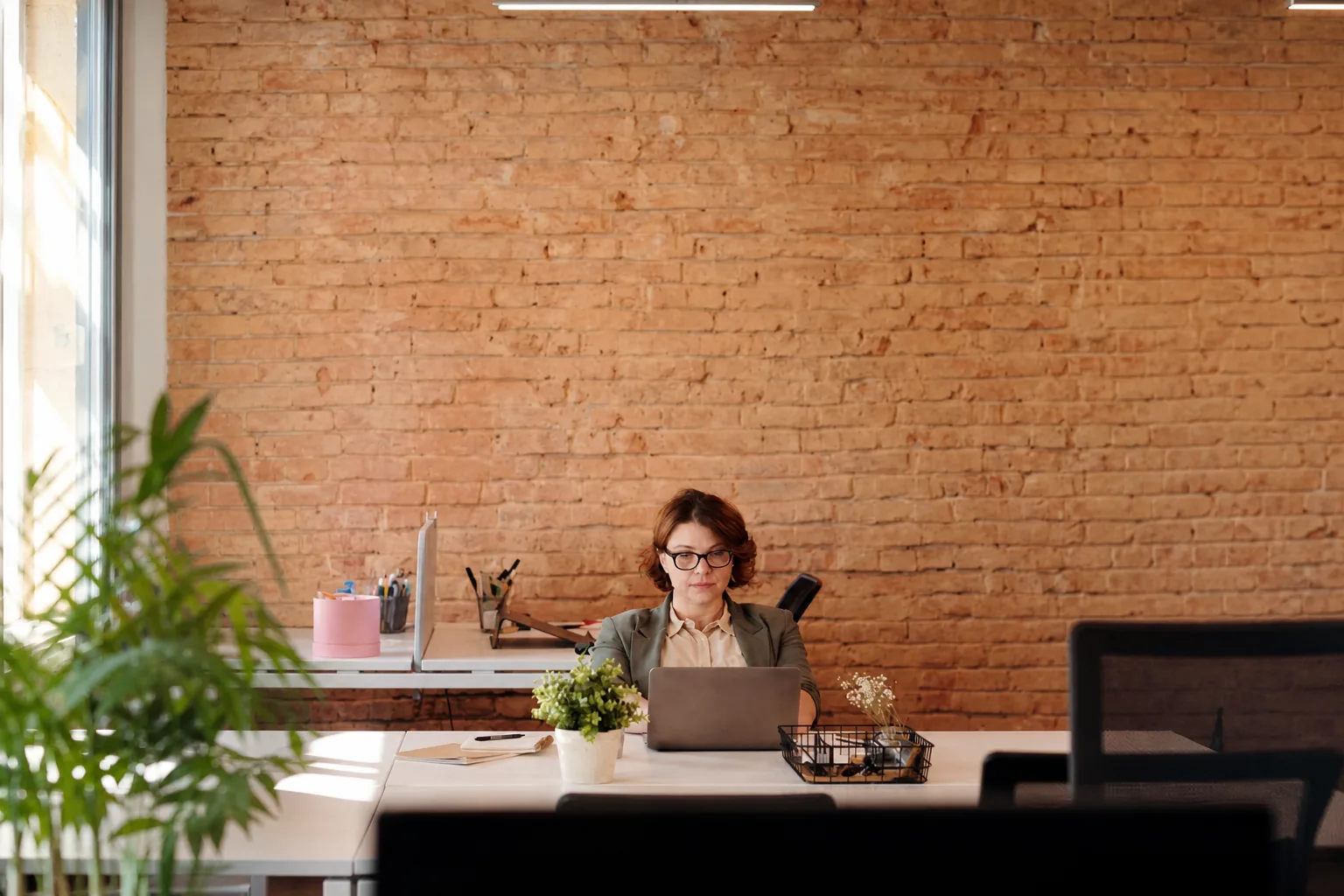 An independent professional working at a laptop in a bright office