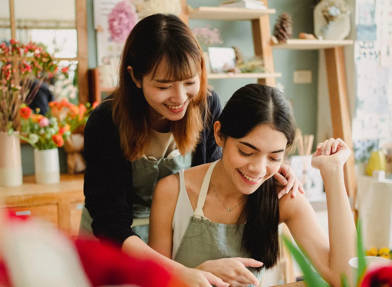 Two florists working together inside a small flower shop